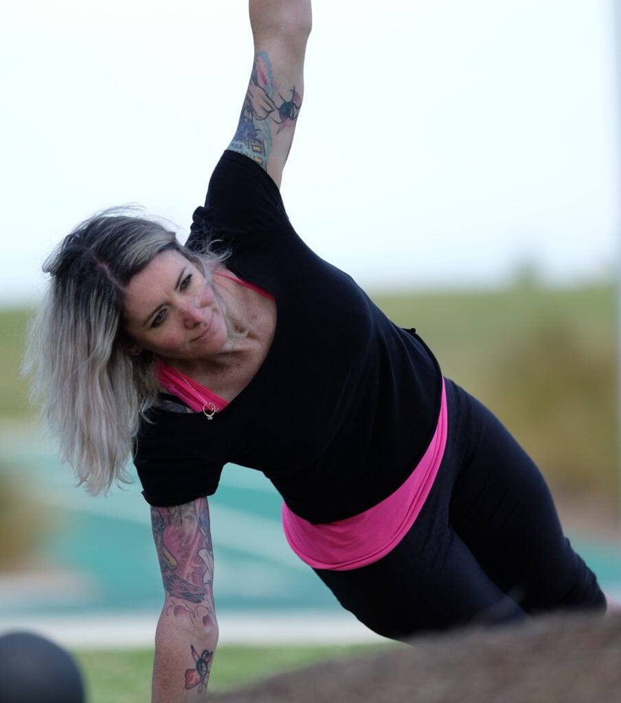 a personal trainer demonstrating an exercise outdoor in melbourne